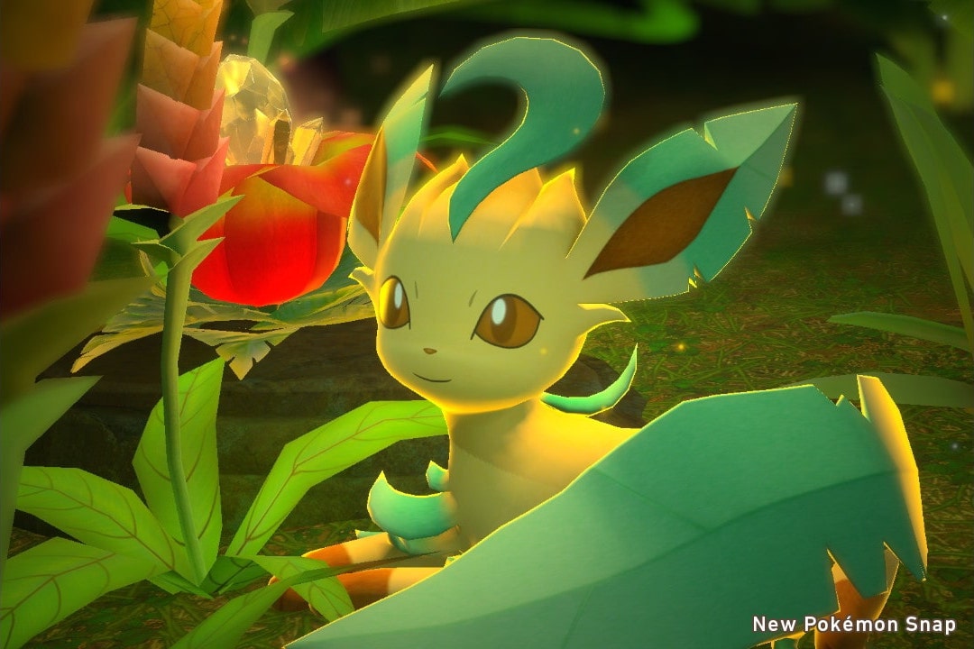A leafeon laying down next to a glowing flower.