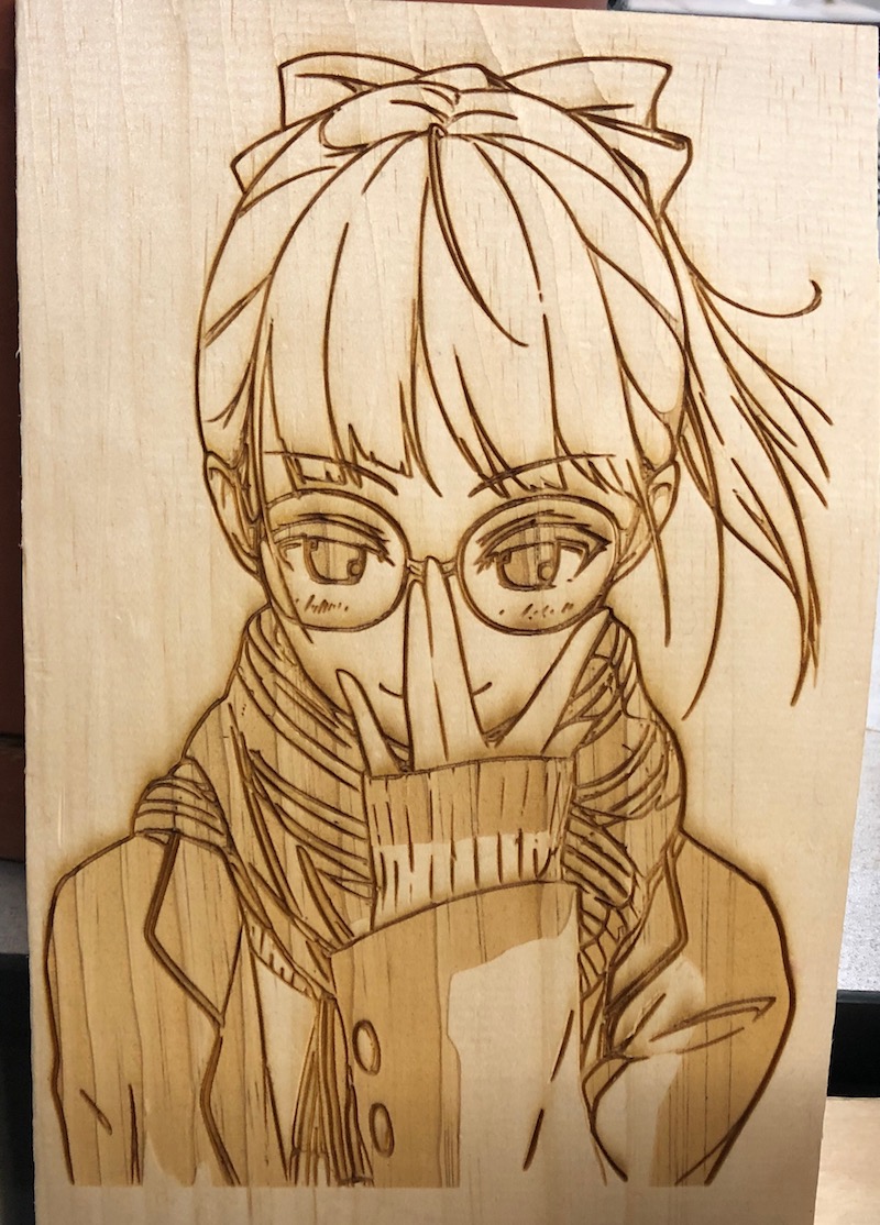 The final result of the girl with glasses artwork laser-cut on a piece of wood.